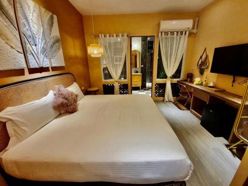 a bedroom with a large white bed with a desk at MiM House in Hengchun