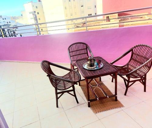 2 sillas y una mesa en el balcón en Appartment Majorelle entier au Centre Ville Kenitra en Kenitra