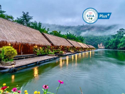 um rio com uma fileira de casas e flores em River Kwai Jungle Rafts - SHA Extra Plus em Sai Yok