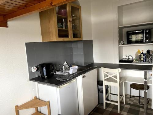 une cuisine avec des armoires blanches et un comptoir dans l'établissement Le mont veyrier, à Annecy