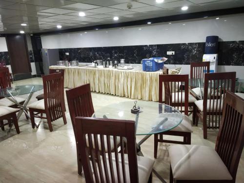 a dining room with a table and chairs and a table and a table at Sohi Residency in New Delhi
