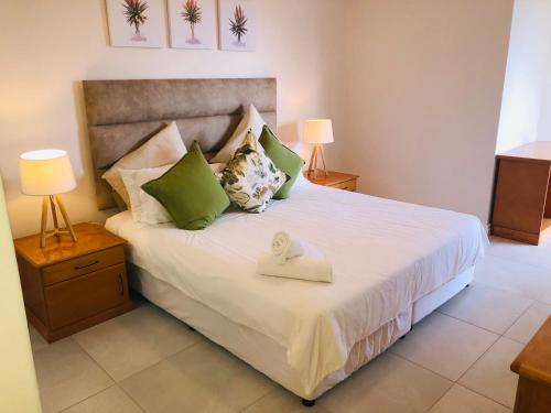 um quarto com uma cama grande e 2 candeeiros em 22 Kyalanga Beachfront Apartment em Durban
