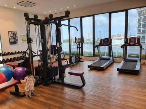 a child standing in a gym with several exercise bikes at Nice stay in heart of Kota Bharu@Troika,free Wifi. in Kota Bharu