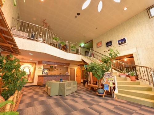 a large lobby with a staircase and a living room at Hotel Parkway in Teshikaga
