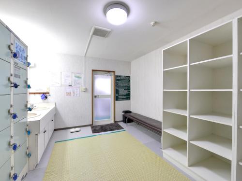 a bathroom with white shelves and a yellow rug at Hotel Parkway in Teshikaga