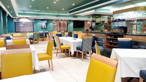 Sparkling Water Hotels & Spa في روستنبرج: غرفة طعام مع طاولات وكراسي صفراء