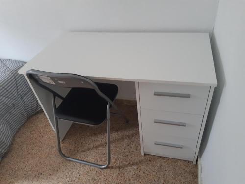 a white desk with a chair next to a bed at Room in Guest room - Peaceful accommodation in Madrid near Atocha in Madrid