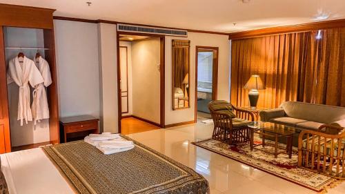 a hotel room with a bed and a living room at K Park Grand Hotel in Surat Thani