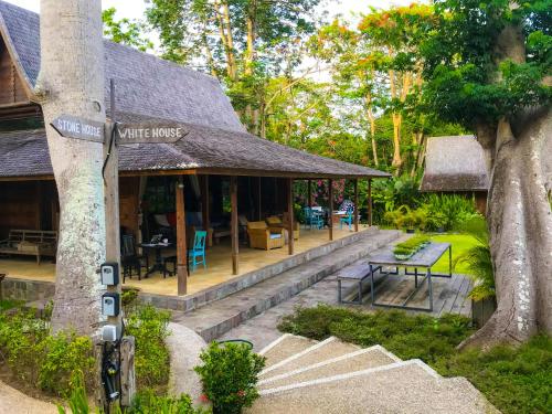una casa bianca con un cartello su un albero di Chanteak Bali a Jimbaran