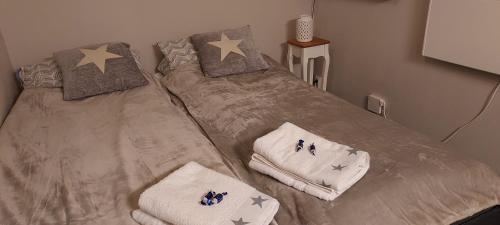 two beds in a bedroom with stars and towels at Polaris Homes Huippu in Syöte