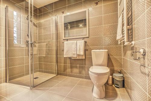 a bathroom with a toilet and a glass shower at Vilhelmhaus in Dėdeliškės