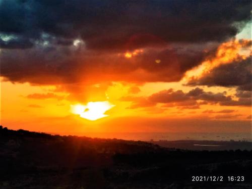 a sunset with the sun setting in the sky at Country-Style House by Nature and Water in Gita