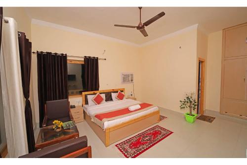 a bedroom with a bed and a flat screen tv at FabHotel Corbett Green View Garden and Stay in Rāmnagar