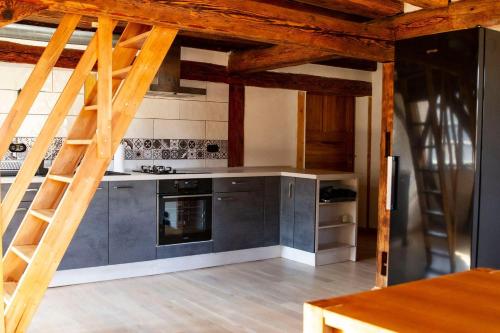une cuisine avec des placards bleus et une échelle en bois dans l'établissement Schloss-Muehlen, à Horb am Neckar