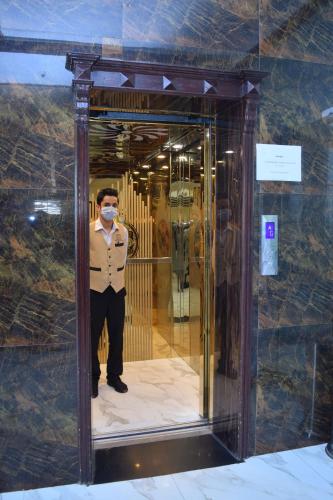 a man wearing a mask standing in a mirror at Swat Palace Hotel By Northin in Mām Derai