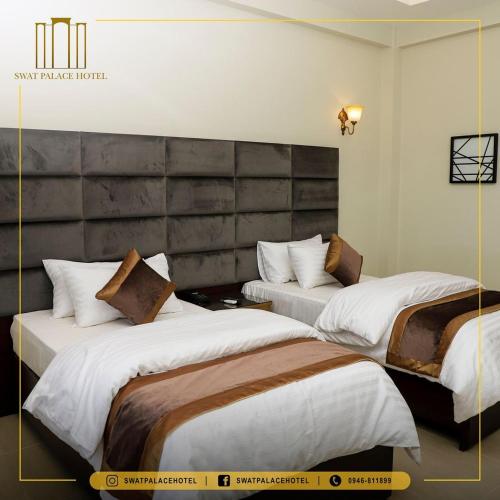 two beds in a hotel room with a large headboard at Swat Palace Hotel By Northin in Mām Derai