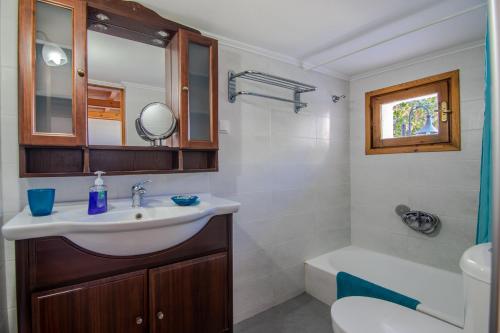 a bathroom with a sink and a toilet and a mirror at Ismini Apartments in Kalyves