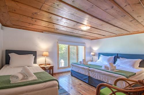 two beds in a room with wooden ceilings at Ismini Apartments in Kalyves