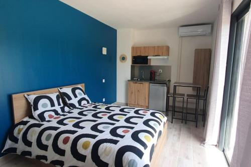 1 dormitorio con cama y pared azul en Studio Provence, en Istres