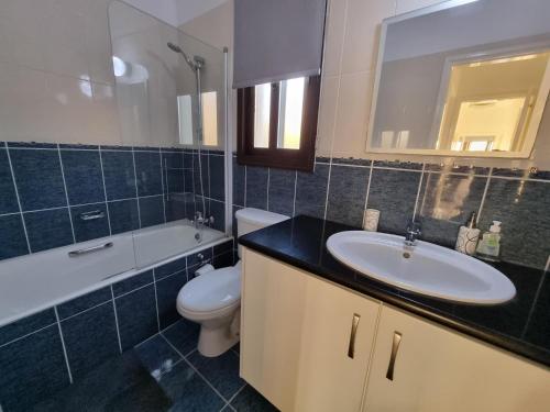 a bathroom with a sink and a toilet and a mirror at Villa Phoenix in Secret Valley in Paphos City