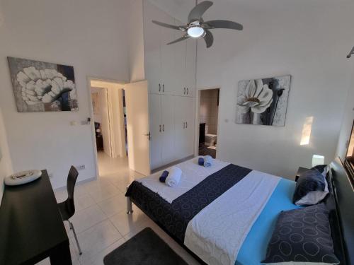 a bedroom with a bed and a ceiling fan at Villa Phoenix in Secret Valley in Paphos City
