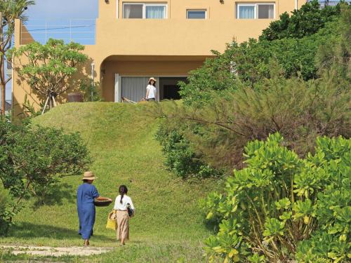 a man and a woman walking down a hill at Villa Kukuru in Ginoza