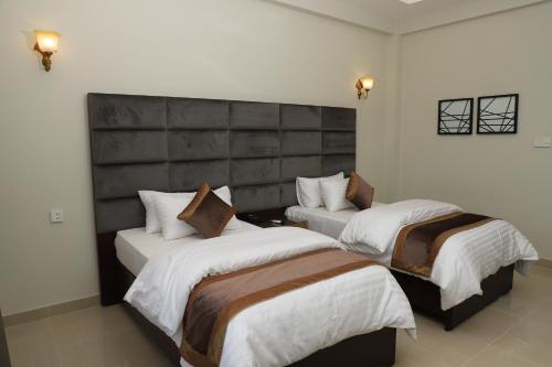 a hotel room with two beds in a room at Swat Palace Hotel By Northin in Mām Derai