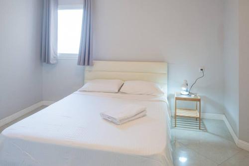 ネタニヤにあるRoyal Aparatment on the Sea , Blvd Nitza 34の白いベッド(タオル2枚付)が備わるベッドルームです。