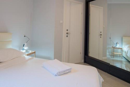 a bedroom with a white bed and a large mirror at Royal Aparatment on the Sea , Blvd Nitza 34 in Netanya