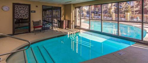 a swimming pool in a hotel with a large window at Grand Lodge 1-Bedroom Condo with 3 Queens & Close to Everything condo in Crested Butte