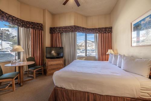 ein Hotelzimmer mit einem Bett und einem TV in der Unterkunft Cozy Pet-Friendly King Studio in Mt, Crested Butte condo in Crested Butte