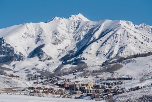 a resort in the mountains with snow covered mountains at Grand Lodge Condo in the Heart of Mt Crested Butte condo in Crested Butte
