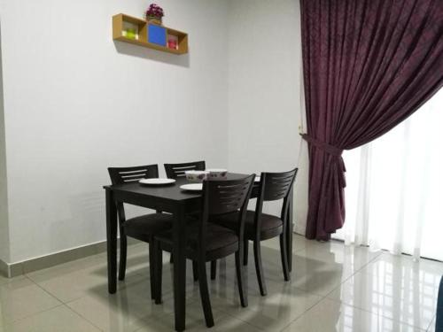 a dining room table with black chairs and a curtain at Teduhan Kasih Homestay in Putrajaya