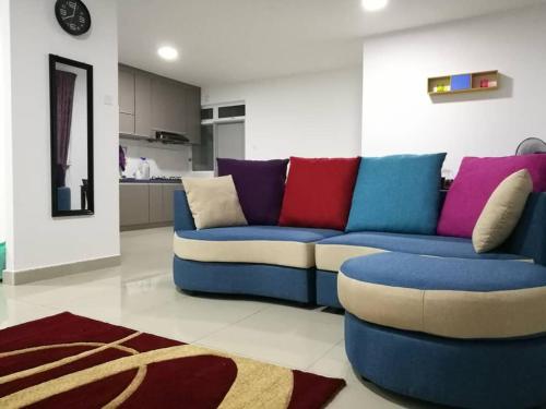a living room with a blue couch with colorful pillows at Teduhan Kasih Homestay in Putrajaya