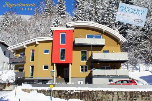 a building in the snow with a sign in front at Appartements Cilli in Neukirchen am Großvenediger