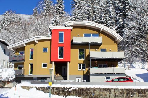 a building in the snow with a car in front at Appartements Cilli in Neukirchen am Großvenediger
