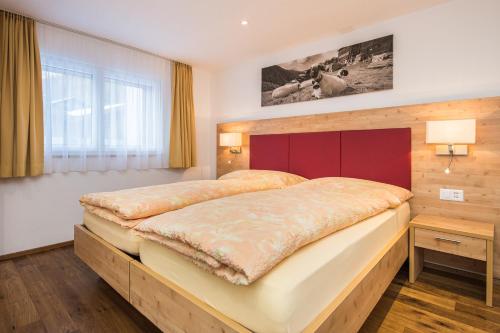 1 dormitorio con 1 cama grande y cabecero rojo en Ferienhaus Matterhorngruss en Zermatt