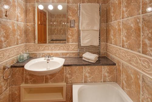 y baño con lavabo y bañera. en Rose Cottages, en Alnwick