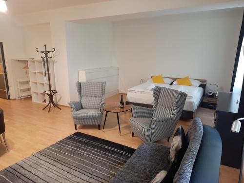 1 dormitorio con 1 cama, 2 sillas y sofá en Apartmán Nad Kolonádou, en Karlovy Vary