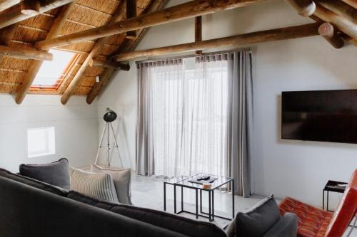 a living room with a couch and a tv at Das Loft in Paternoster