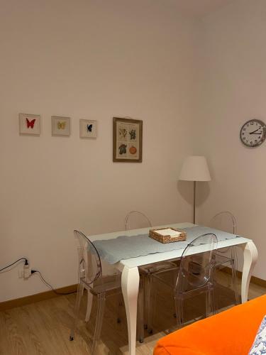 a dining room table with chairs and a clock on the wall at PALAZZO MARCHETTI in Ancona