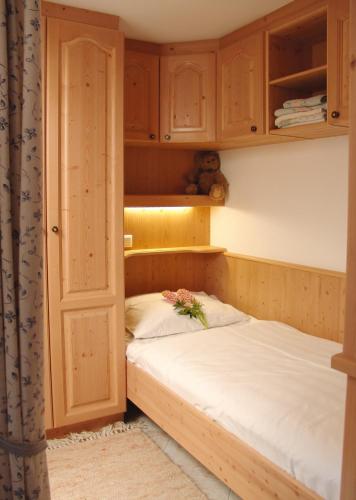 a small bedroom with a bed and wooden cabinets at Das kleine Berghotel in Liesing