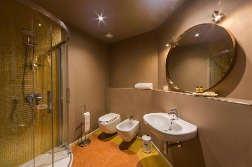 a bathroom with a sink and a toilet and a mirror at BED and BIKE - BERGAMO Dream House in Bergamo