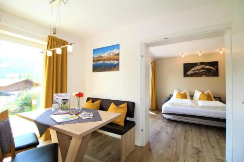 a room with a bed and a desk with a table at Appartements Cilli in Neukirchen am Großvenediger