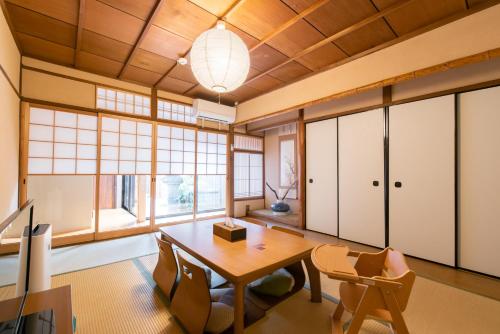 ein Esszimmer mit einem Tisch, Stühlen und Fenstern in der Unterkunft JPRESERVE Toji in Kyoto