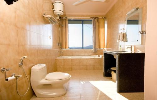 a bathroom with a toilet and a sink and a tub at Amazing Hilltop 4 BHK Villa with Private Pool near Candolim in Candolim