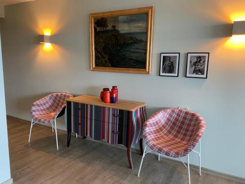 a room with two chairs and a table and a painting at Das Hotel Ostseeblick in Lütjenburg