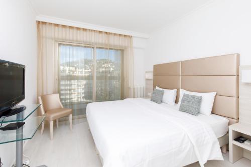 - une chambre blanche avec un grand lit et une télévision dans l'établissement On La Croisette deluxe 2 bedrooms 2 baths, à Cannes