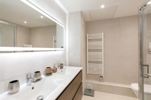 une salle de bain blanche avec un lavabo et une douche dans l'établissement On La Croisette deluxe 2 bedrooms 2 baths, à Cannes