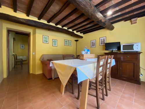 a dining room with a table and a couch at Fattoria Agriturismo Nerbona in Casole dʼElsa
